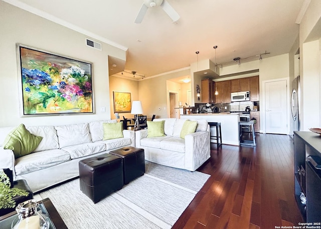 living room featuring visible vents, dark wood-type flooring, ceiling fan, and crown molding