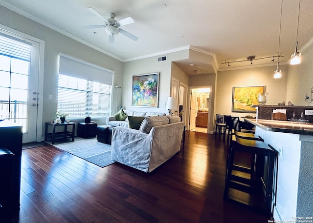 living room with visible vents, track lighting, ceiling fan, ornamental molding, and dark wood-style flooring