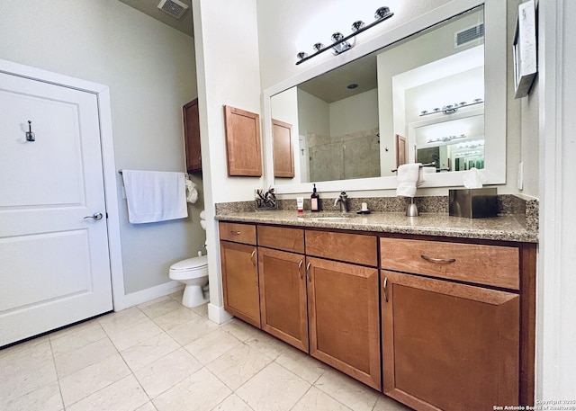 bathroom with visible vents, toilet, a stall shower, and vanity