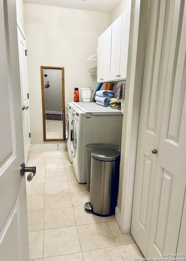 washroom with washing machine and clothes dryer, cabinet space, and marble finish floor