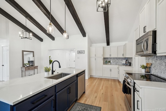 kitchen with a sink, backsplash, white cabinetry, stainless steel appliances, and a chandelier