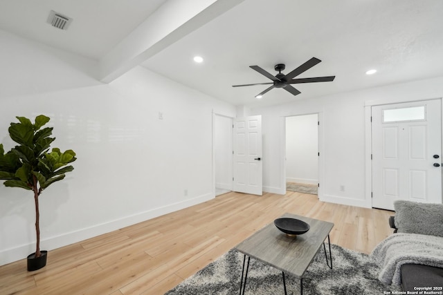 living area with light wood-style flooring, baseboards, visible vents, and ceiling fan