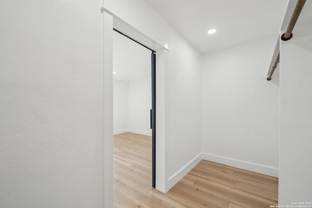 hall featuring recessed lighting, light wood-style flooring, and baseboards