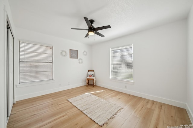 empty room featuring baseboards, ceiling fan, and hardwood / wood-style floors