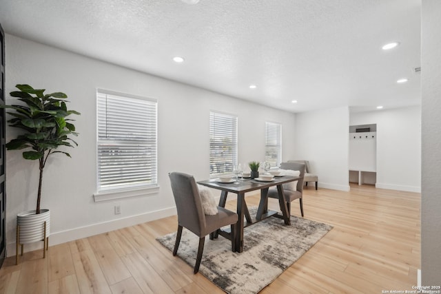 dining area with recessed lighting, light wood-style floors, baseboards, and a textured ceiling