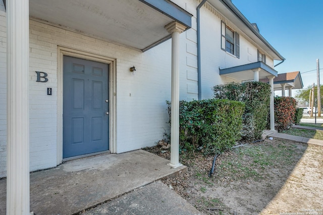 doorway to property with brick siding