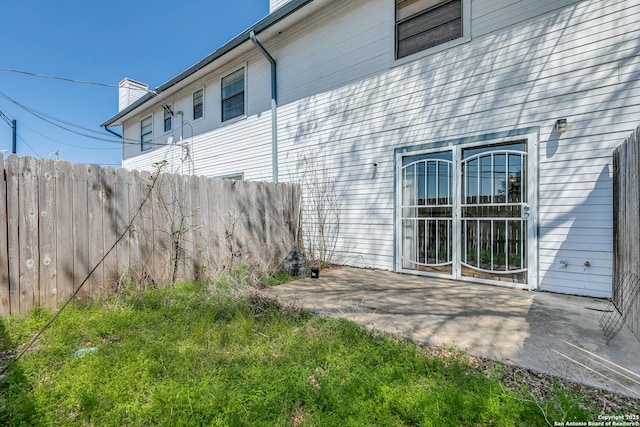 exterior space with a patio, fence, and a chimney