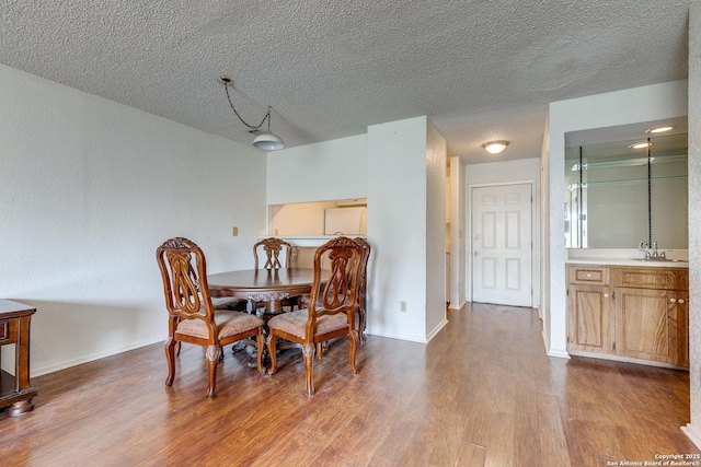 dining space featuring baseboards, dark wood-type flooring, and a textured ceiling