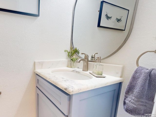 bathroom with vanity and a textured wall