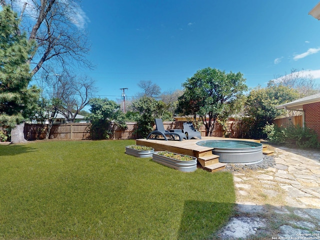 view of yard with a vegetable garden and a fenced backyard