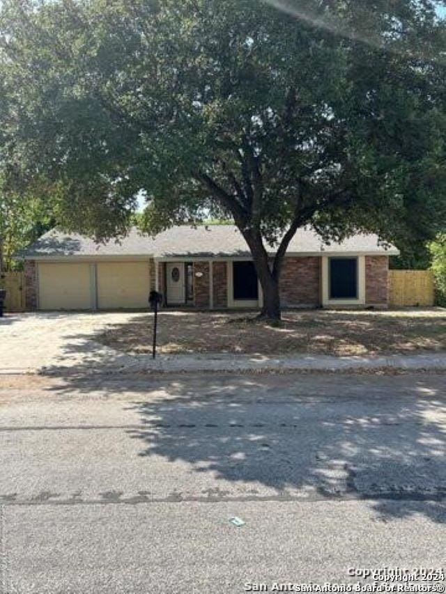 ranch-style house featuring a garage and driveway