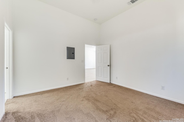 spare room with electric panel, visible vents, baseboards, and carpet flooring