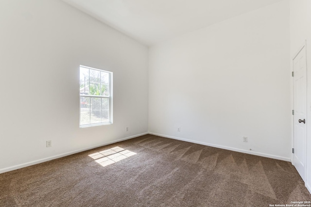 carpeted empty room featuring baseboards