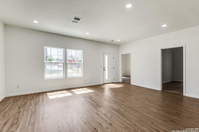 unfurnished living room with visible vents, recessed lighting, baseboards, and wood finished floors