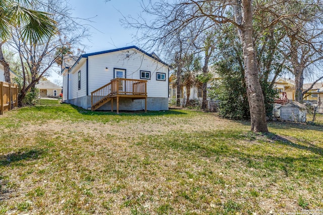 rear view of house with fence and a lawn