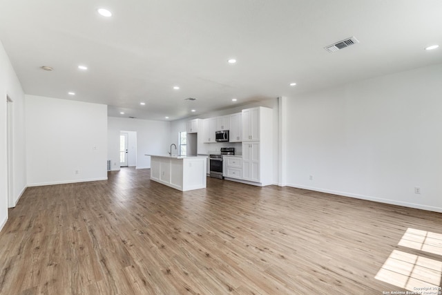 unfurnished living room with light wood finished floors, visible vents, and recessed lighting