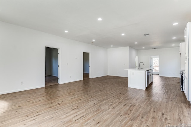 unfurnished living room featuring a sink, visible vents, recessed lighting, and light wood finished floors