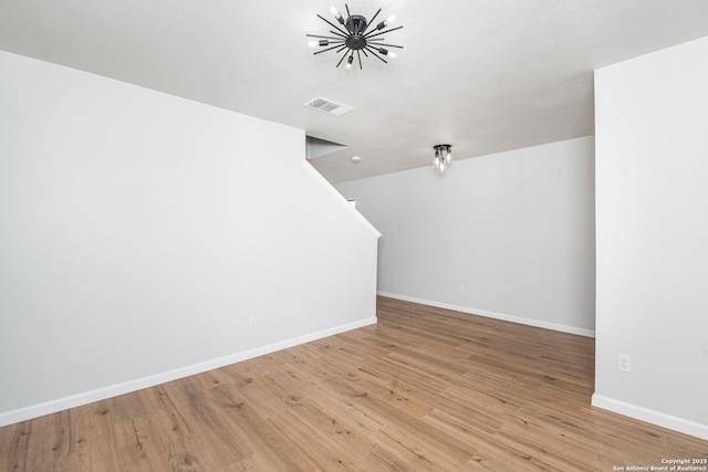 interior space with an inviting chandelier, light wood-style floors, visible vents, and baseboards