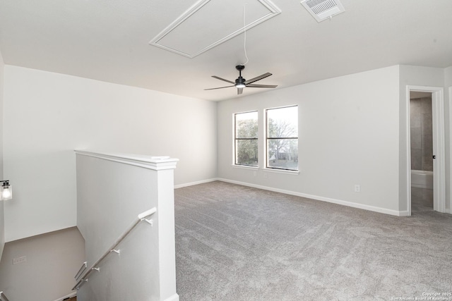 spare room featuring attic access, carpet flooring, baseboards, and visible vents