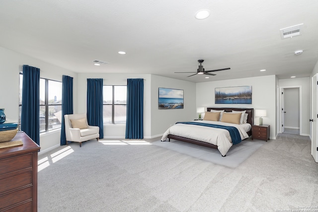 bedroom featuring light carpet, visible vents, baseboards, and ceiling fan