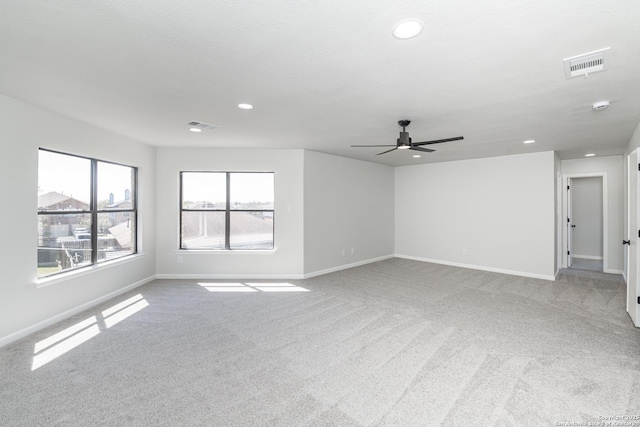 carpeted spare room with recessed lighting, a ceiling fan, visible vents, and baseboards