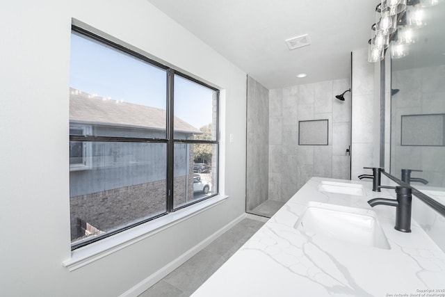 full bath featuring walk in shower, visible vents, and a sink