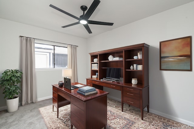 office with light colored carpet, a ceiling fan, and baseboards