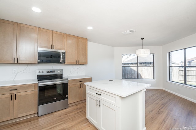 kitchen with visible vents, light wood-style flooring, light brown cabinetry, stainless steel appliances, and decorative backsplash