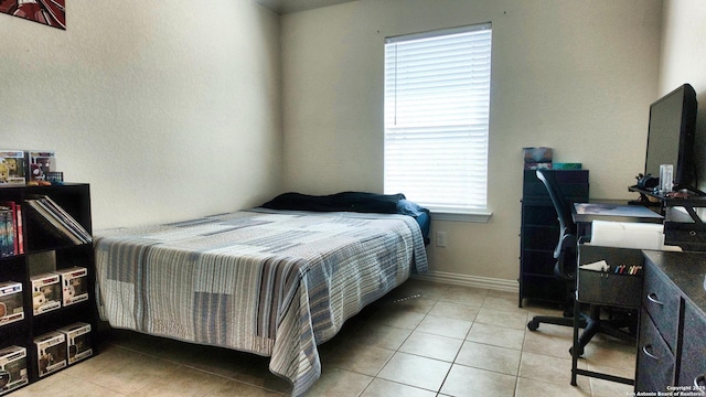 bedroom featuring light tile patterned floors and baseboards