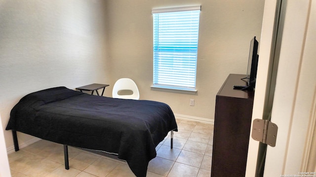 bedroom with light tile patterned flooring and baseboards