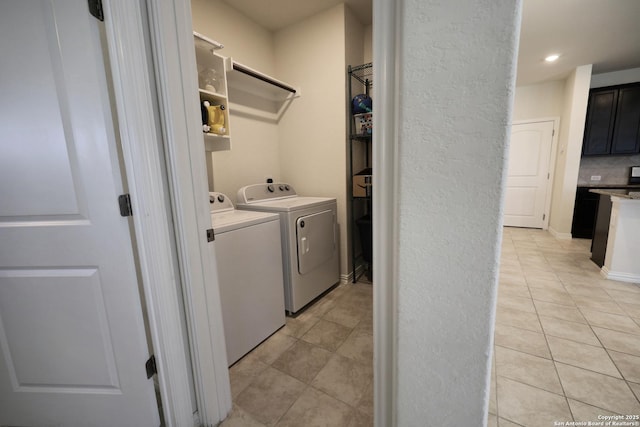 laundry area with light tile patterned floors, laundry area, and washing machine and dryer