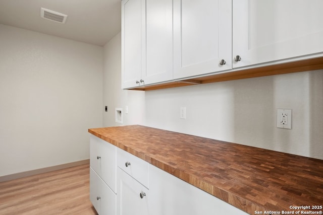 301 Vip Dr, Canyon Lake, TX 78133 - kitchen with visible vents, light wood-style flooring, white cabinets, butcher block counters, and baseboards
