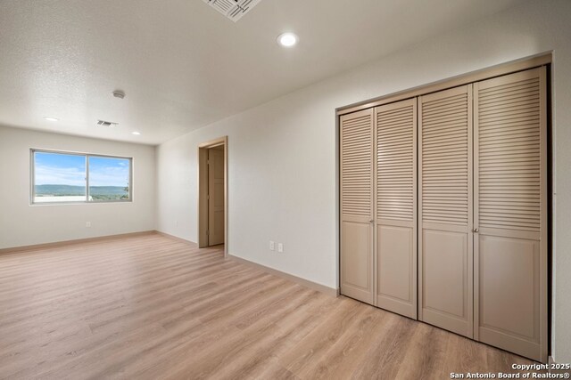 301 Vip Dr, Canyon Lake, TX 78133 - unfurnished bedroom with a closet, visible vents, light wood-style flooring, and recessed lighting