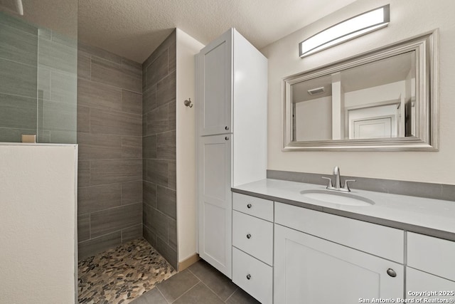 301 Vip Dr, Canyon Lake, TX 78133 - bathroom with tile patterned flooring, a textured ceiling, vanity, and walk in shower