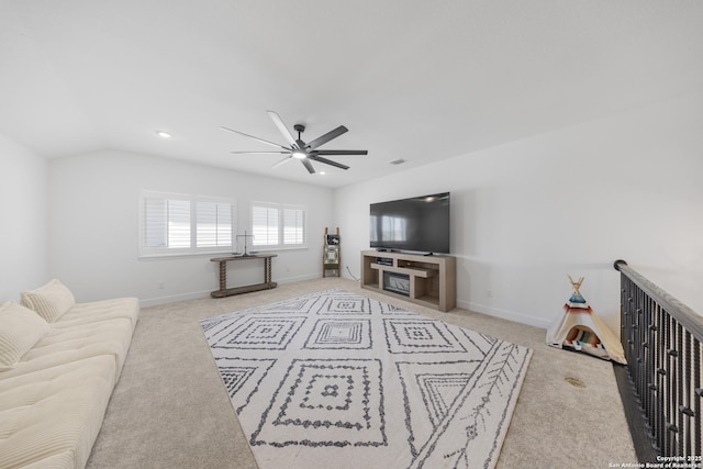 living area featuring baseboards, lofted ceiling, ceiling fan, and carpet flooring