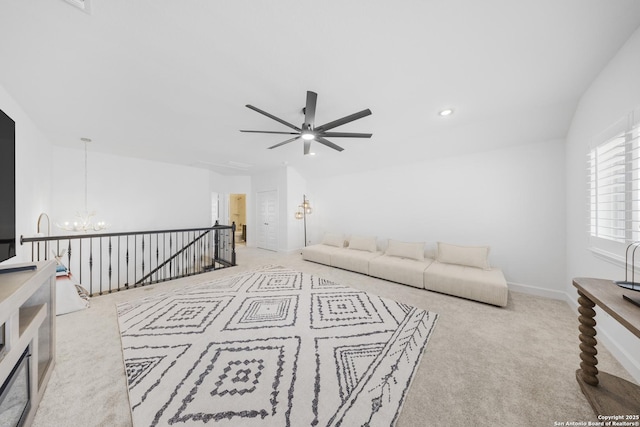 carpeted living area with recessed lighting, baseboards, and ceiling fan with notable chandelier