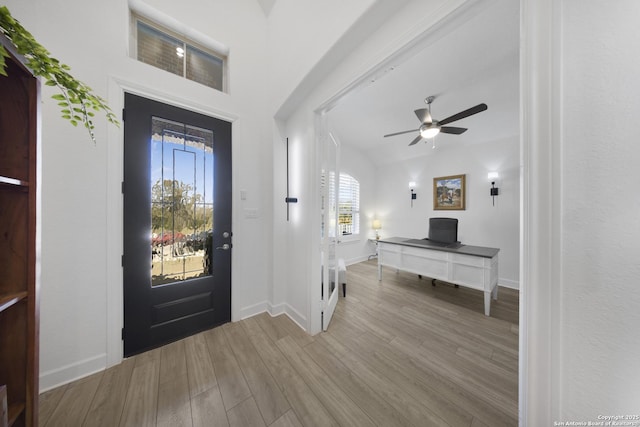 foyer with a ceiling fan, wood finished floors, and baseboards