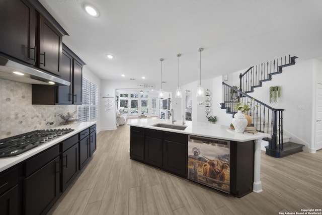 kitchen featuring a sink, dishwasher, stainless steel gas stovetop, and light countertops