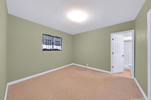 520 Ogden St, San Antonio, TX 78212 - unfurnished bedroom with baseboards, light carpet, a textured ceiling, and ensuite bath