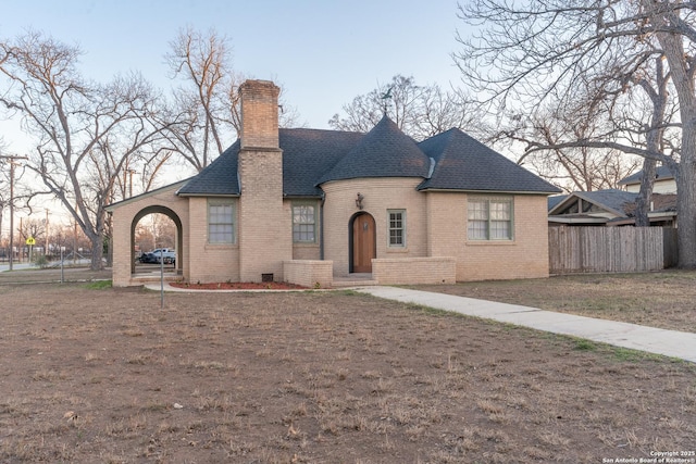 view of front of property featuring fence, roof with shingles, a chimney, a front lawn, and brick siding