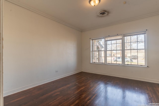 spare room with visible vents, baseboards, dark wood-type flooring, and ornamental molding