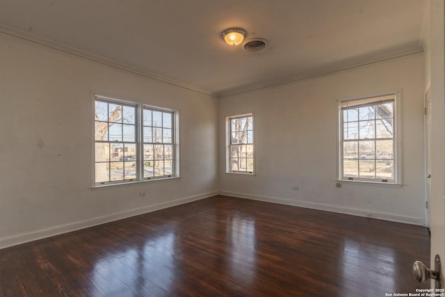 unfurnished room featuring visible vents, wood finished floors, baseboards, and ornamental molding