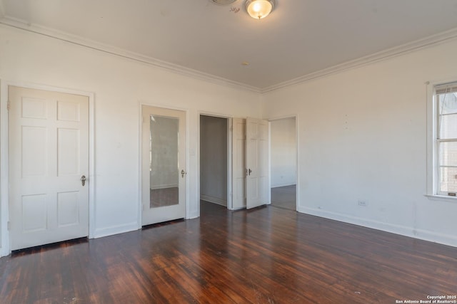 unfurnished bedroom featuring dark wood finished floors, crown molding, and baseboards