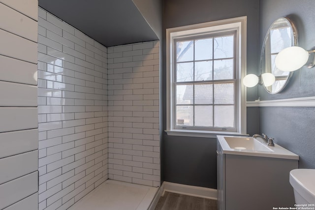 bathroom featuring vanity, toilet, baseboards, and a wealth of natural light