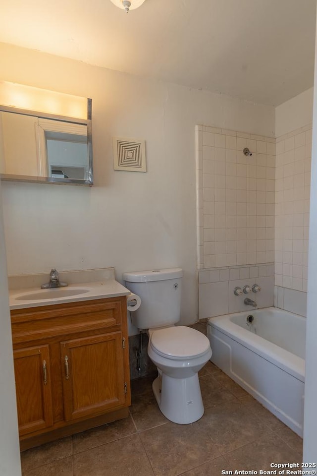 bathroom featuring vanity, toilet, tile patterned flooring, and shower / washtub combination