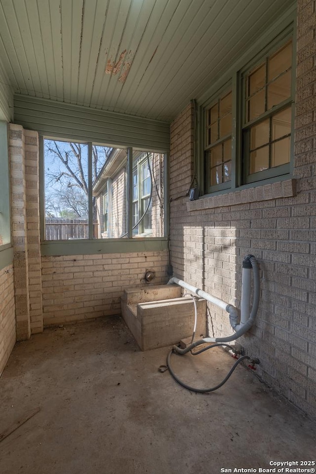 exterior space with brick wall and concrete floors