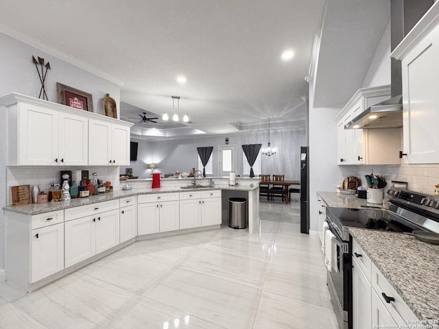 kitchen with white cabinetry, stainless steel range with electric stovetop, a sink, a ceiling fan, and a peninsula