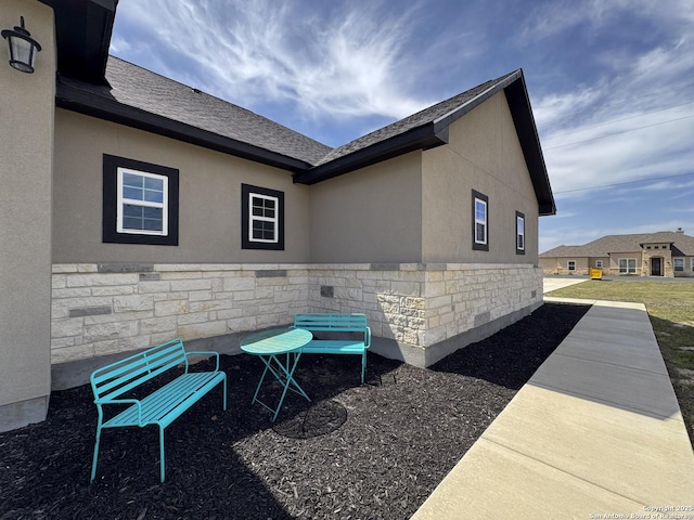 view of home's exterior with stucco siding and stone siding