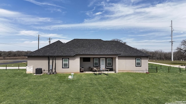 back of house with fence, roof with shingles, stucco siding, a yard, and a patio area