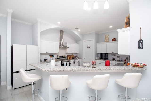 kitchen featuring electric range, white cabinets, tasteful backsplash, and wall chimney exhaust hood